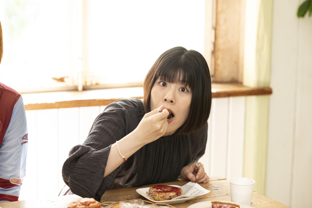 吉田さんがドーナツを食べている写真